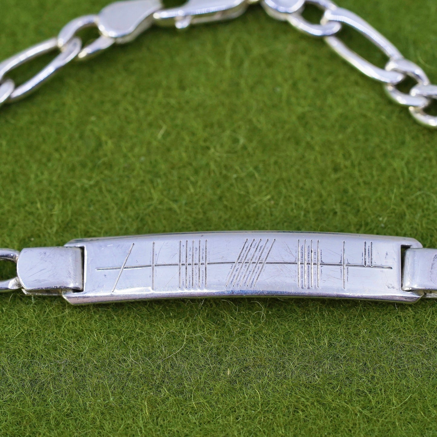 7.25” sterling silver bracelet, 925 figaro chain with line engraved bar tag