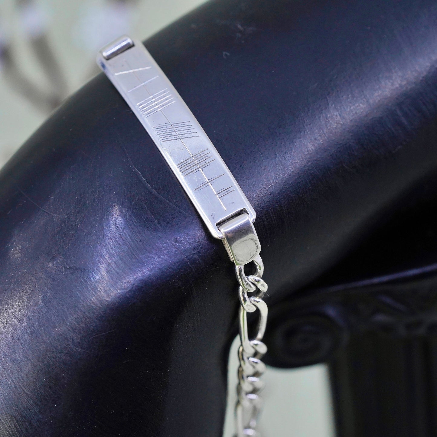 7.25” sterling silver bracelet, 925 figaro chain with line engraved bar tag