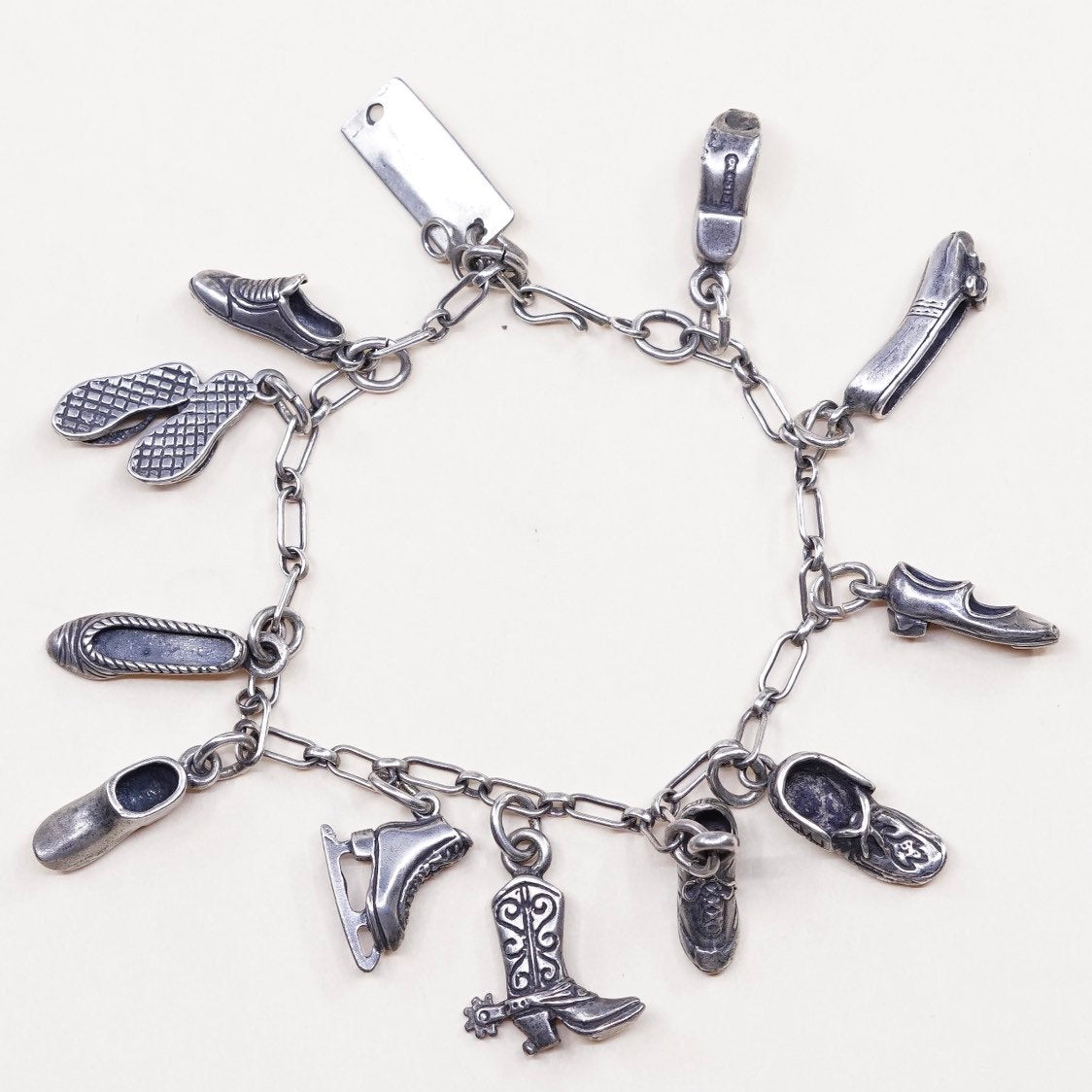 6.5”, beau sterling silver Handmade elongated chain bracelet w/ 11 shoe charms